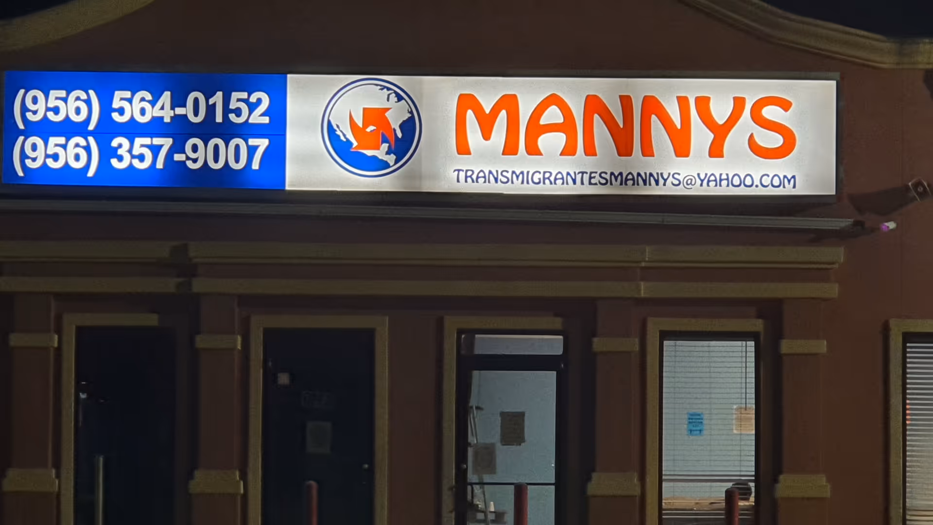Exterior storefront with Manny's sign and contact numbers on a blue panel