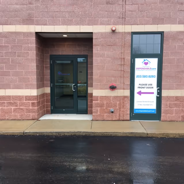 Exterior view of Dependable Care LLC entrance with glass doors and sign.
