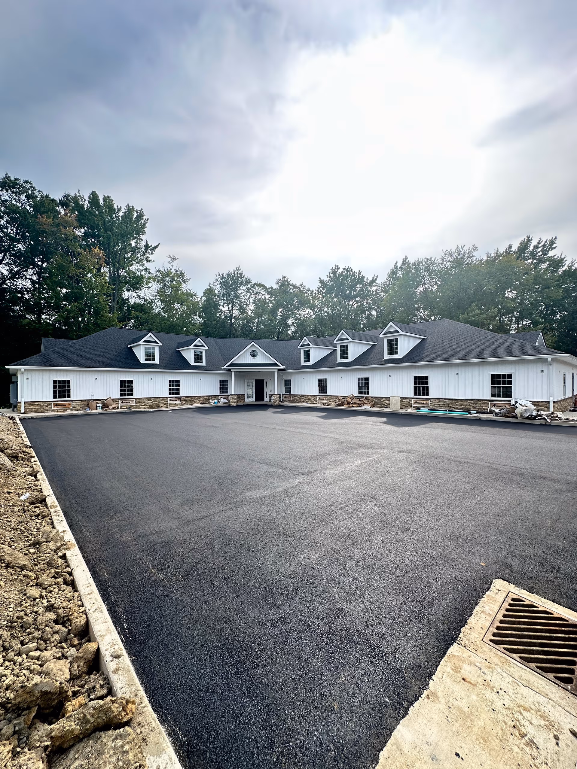 Sherman Springs facility, white, single-story with dormers and a large paved driveway.