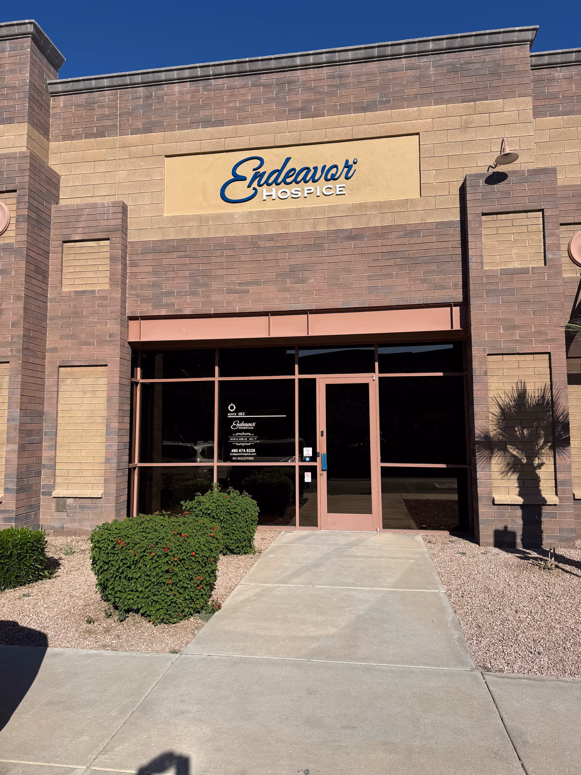 Brick exterior of Endeavor Hospice with glass entrance and landscaping in front