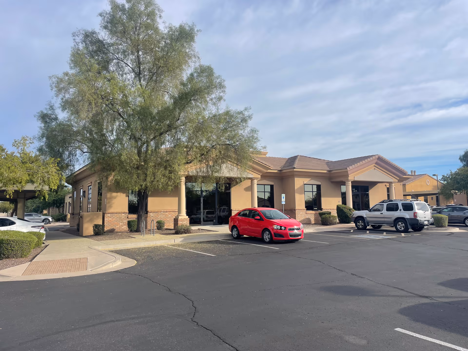 Exterior view of ABC Care, LLC showing the front entrance, parked cars, and trees.