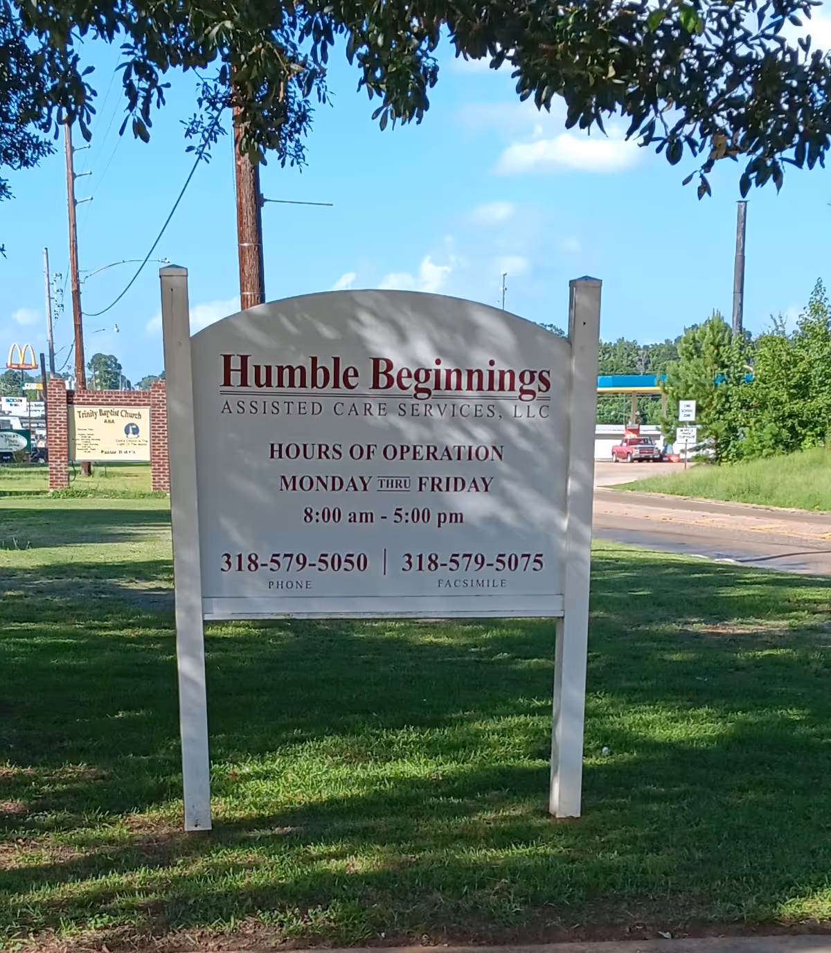 Outdoor sign for Humble Beginnings Assisted Care Services LLC beside a grassy lawn.