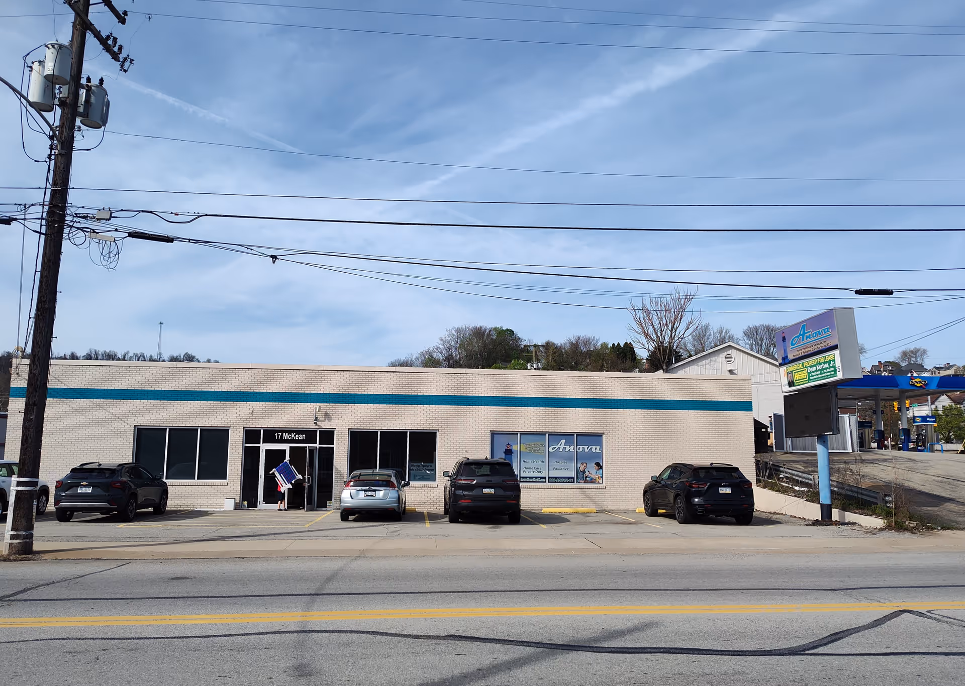 Anova Health Care exterior building front with blue stripe and parked cars.