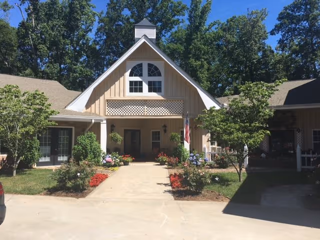 Front entrance of Cannonwood Village senior living facility with landscaped walkway and trees.