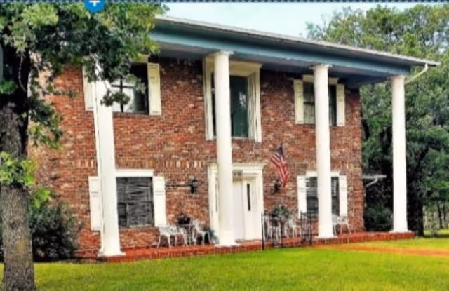 Brick two-story elder care home with white columns and a front porch.
