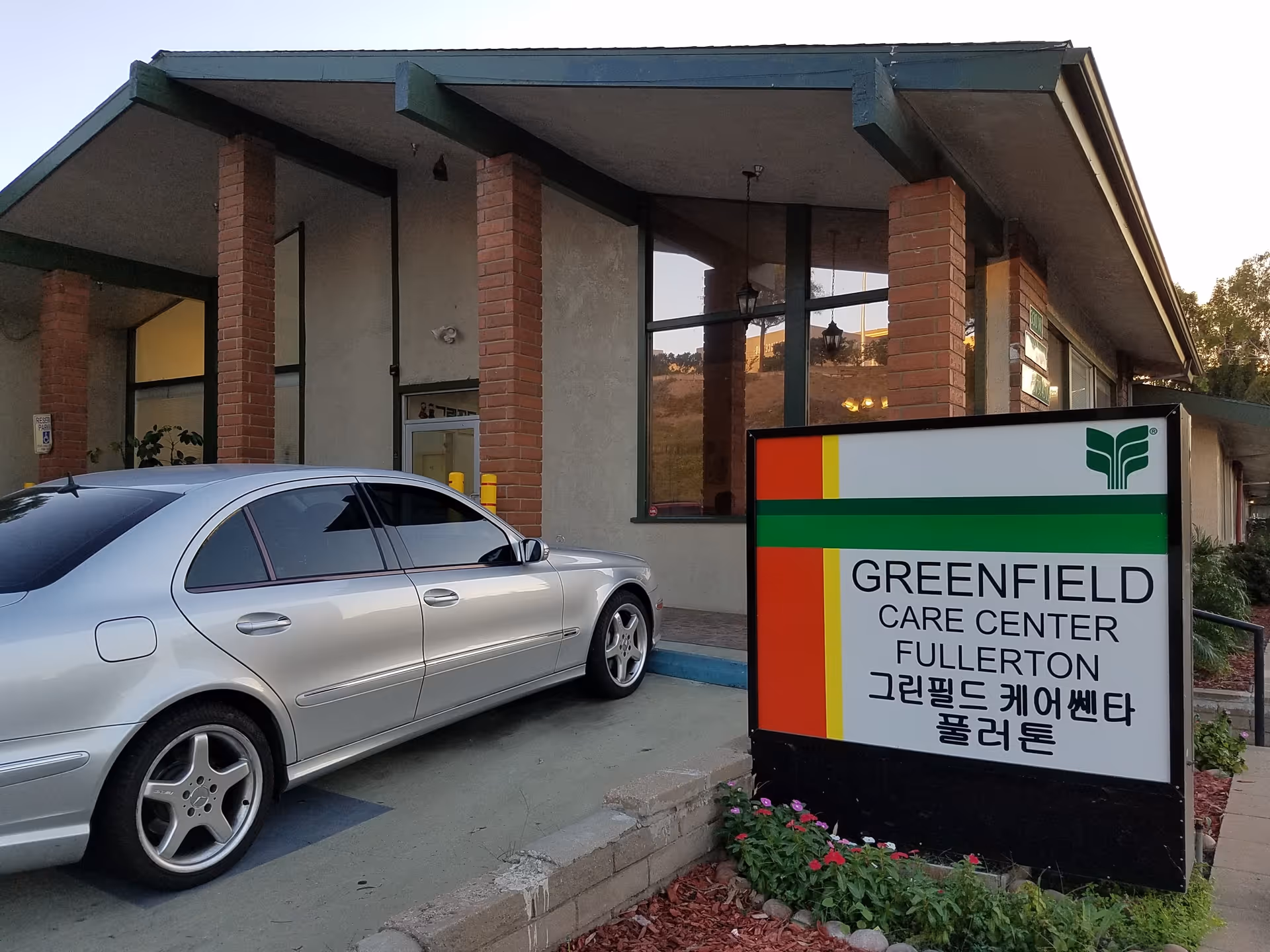 Exterior view of Greenfield Care Center Fullerton with a parked silver car.