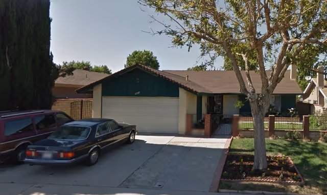 Front exterior of Jennifer Home: a single-story house with a garage, driveway, and trees.