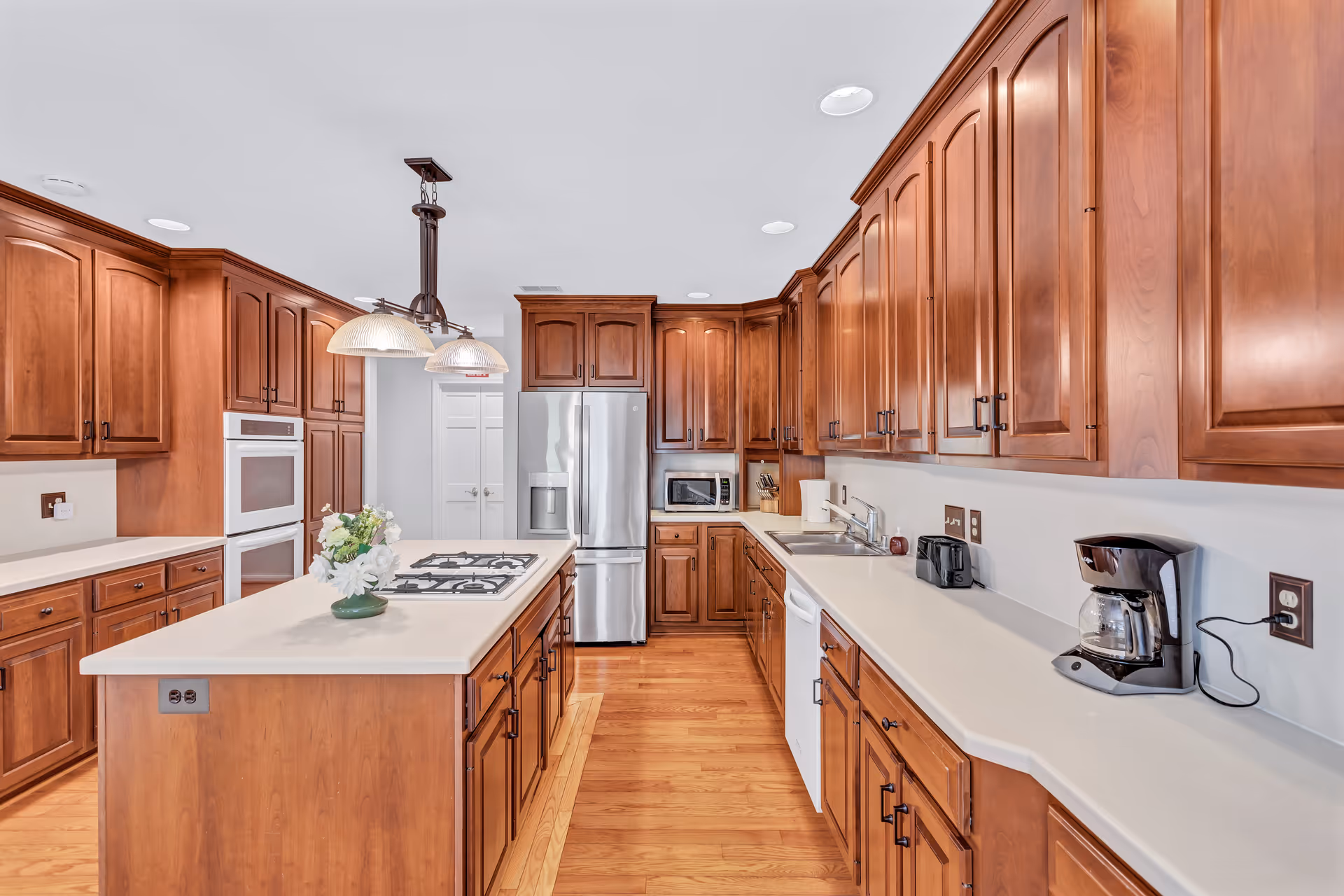 Bright, spacious kitchen with wooden cabinets, island, and stainless steel appliances.
