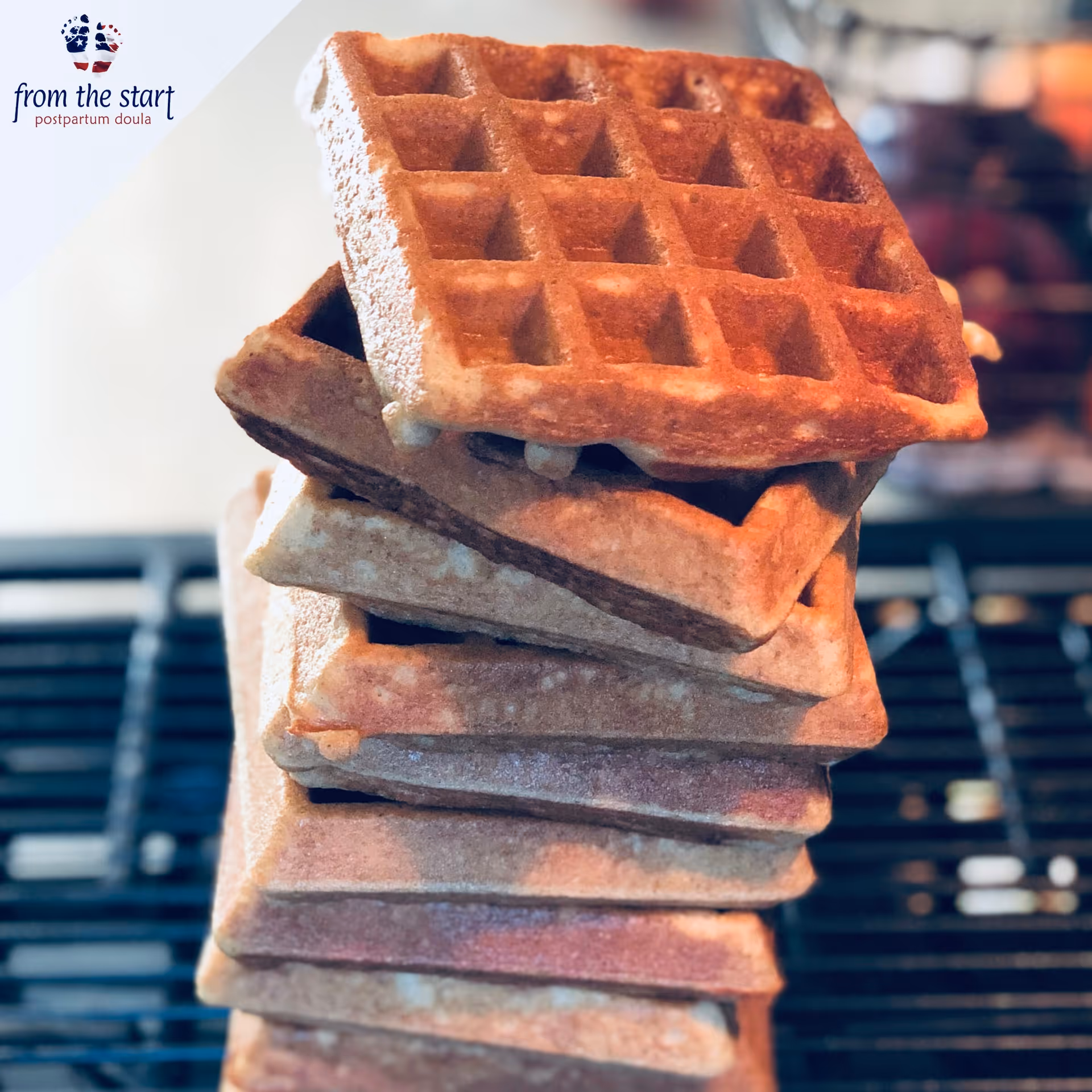 Close-up of stacked waffles on a rack with a logo in the corner.