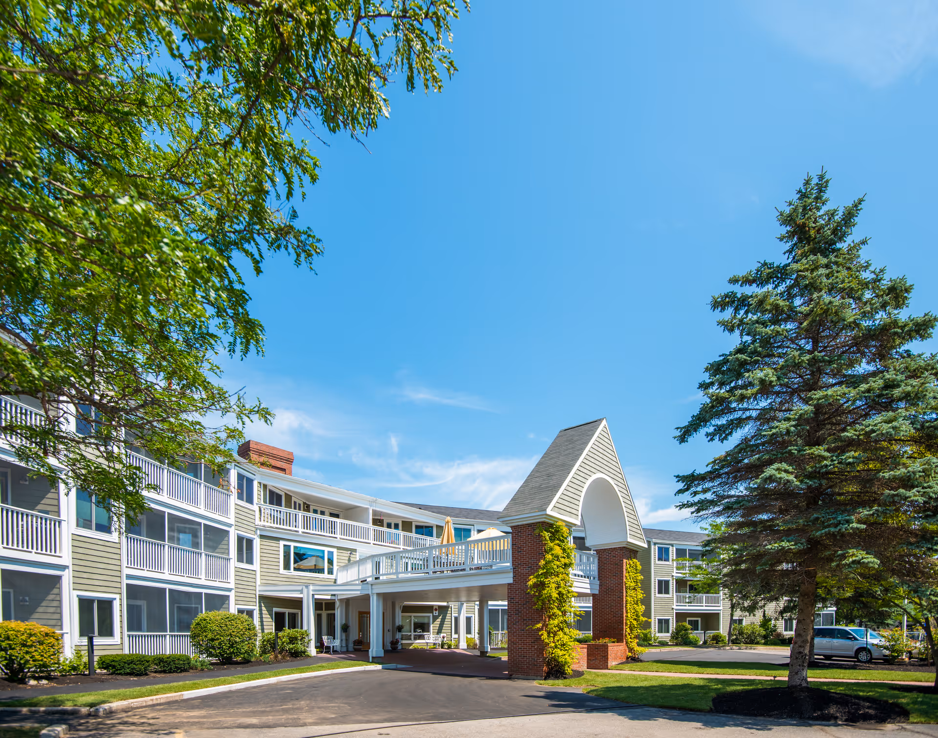 Front view of The Highlands senior living campus with archway entrance.