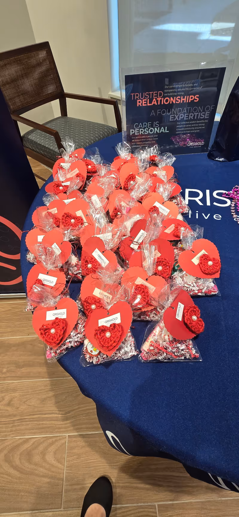 Red heart-shaped tokens wrapped in clear bags arranged on a table inside a care facility.