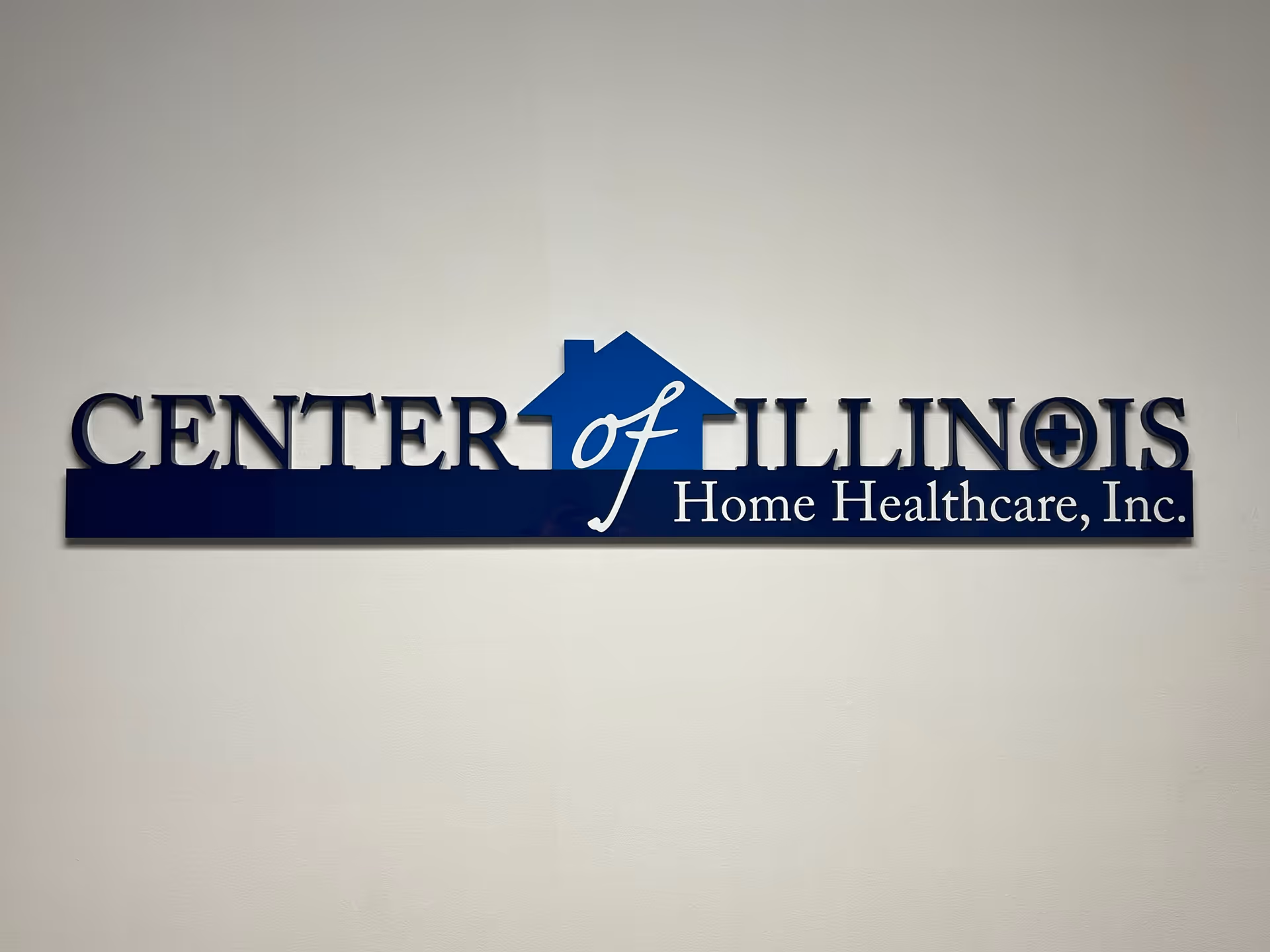 Blue wall sign reads Center of Illinois Home Healthcare, Inc. on a beige wall.