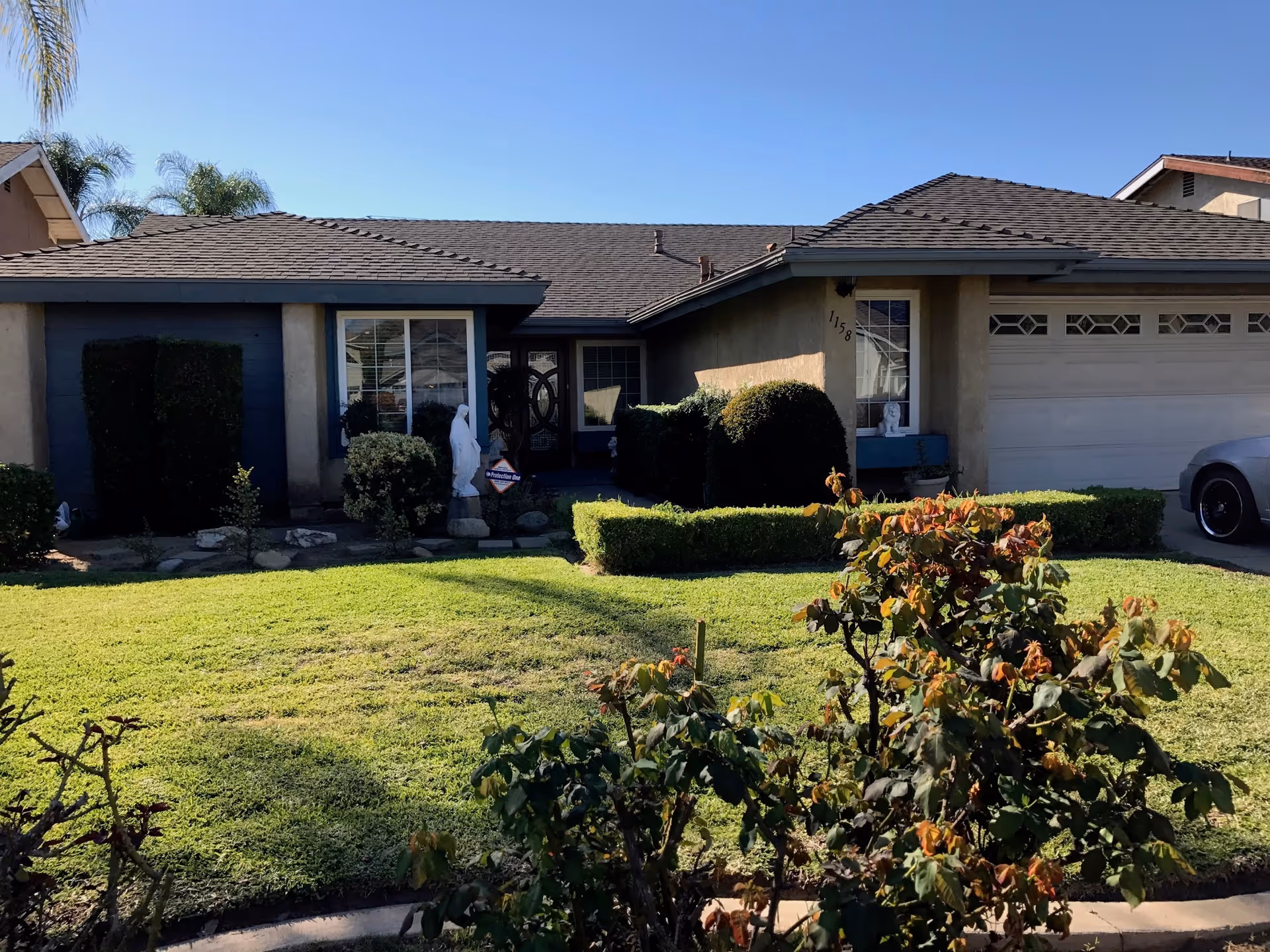 Front exterior of a single-story home with a well-kept lawn and shrubs.
