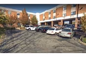 Front view shows a brick senior living building with cars parked in the lot.
