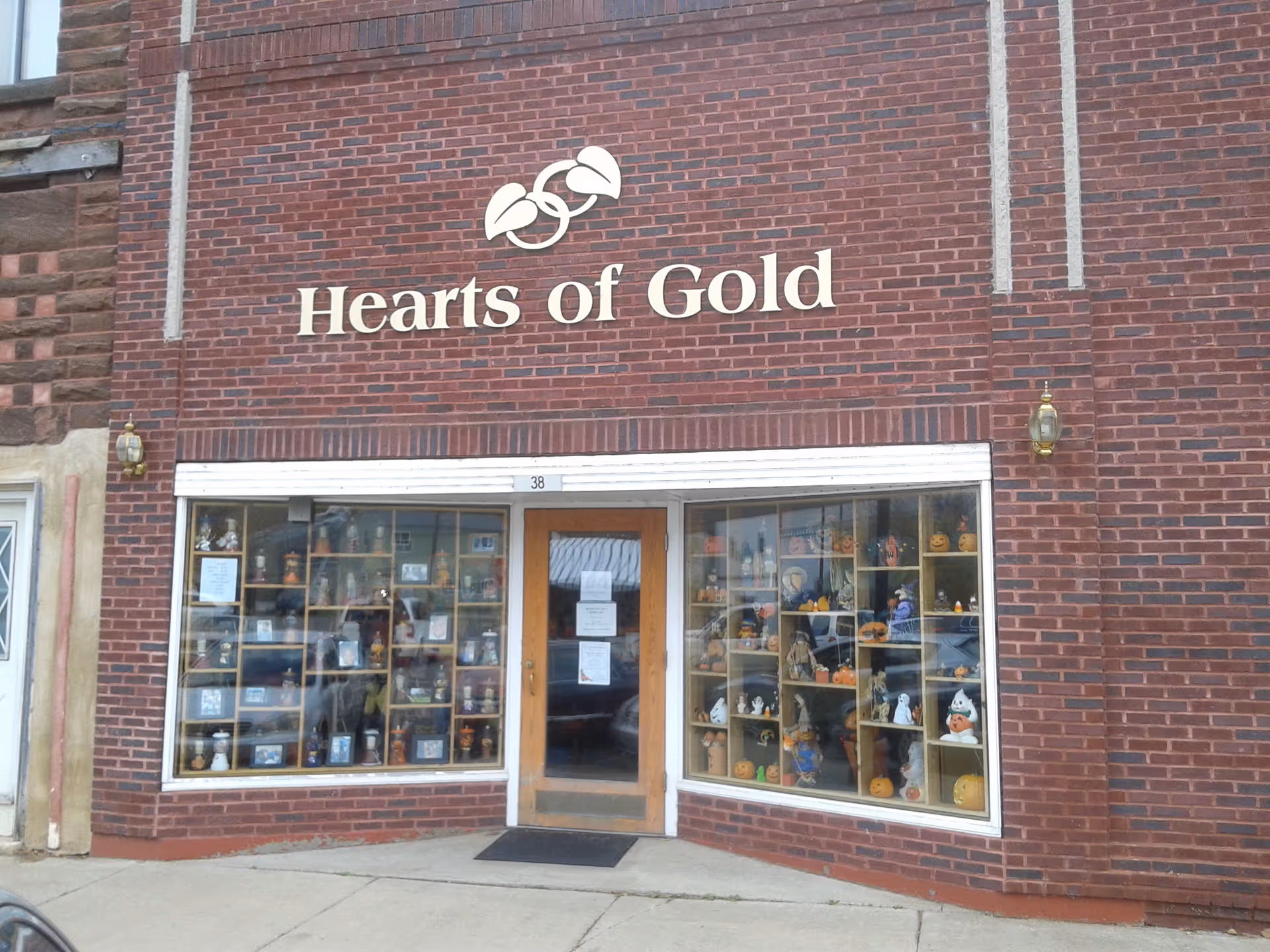 Brick building storefront with Hearts of Gold sign and large display windows.