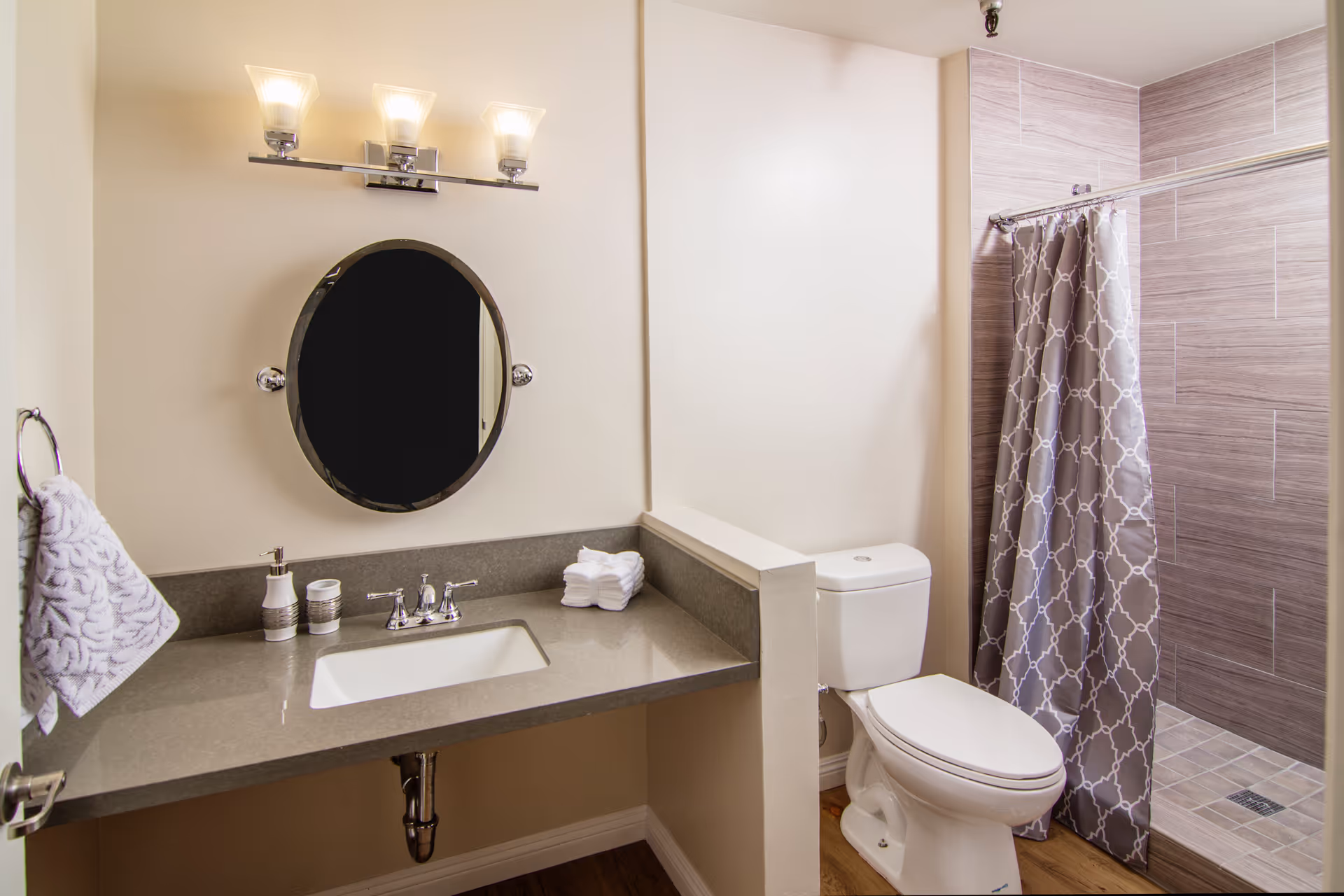 Modern bathroom with sink, mirror, toilet, and tiled shower in neutral tones.