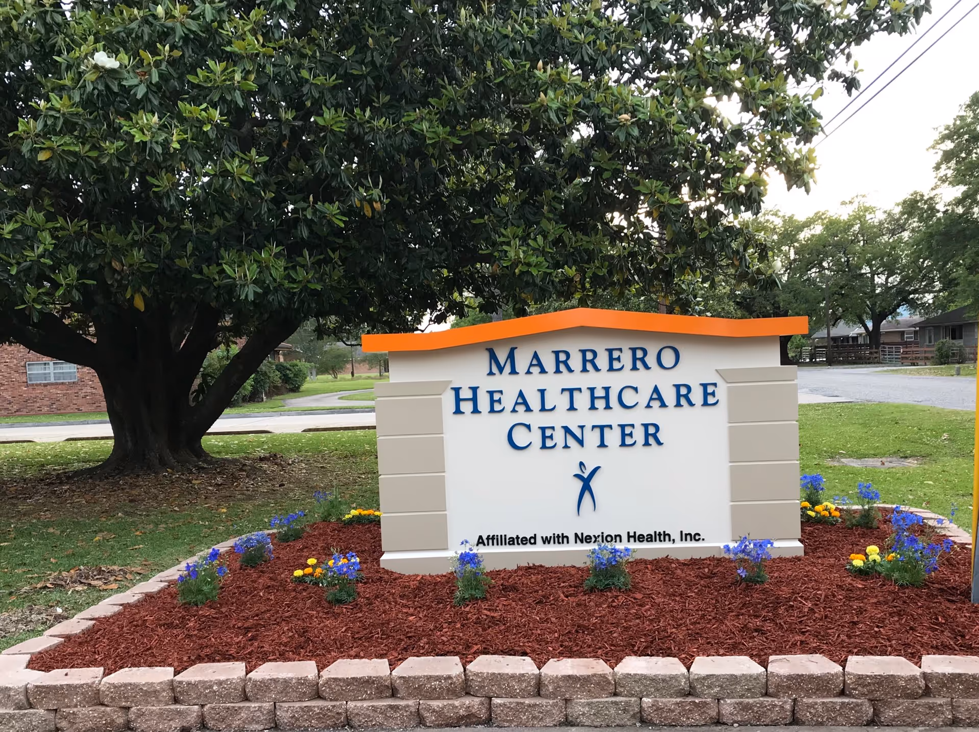 A large Marrero Healthcare Center sign sits in front of landscaped grounds.