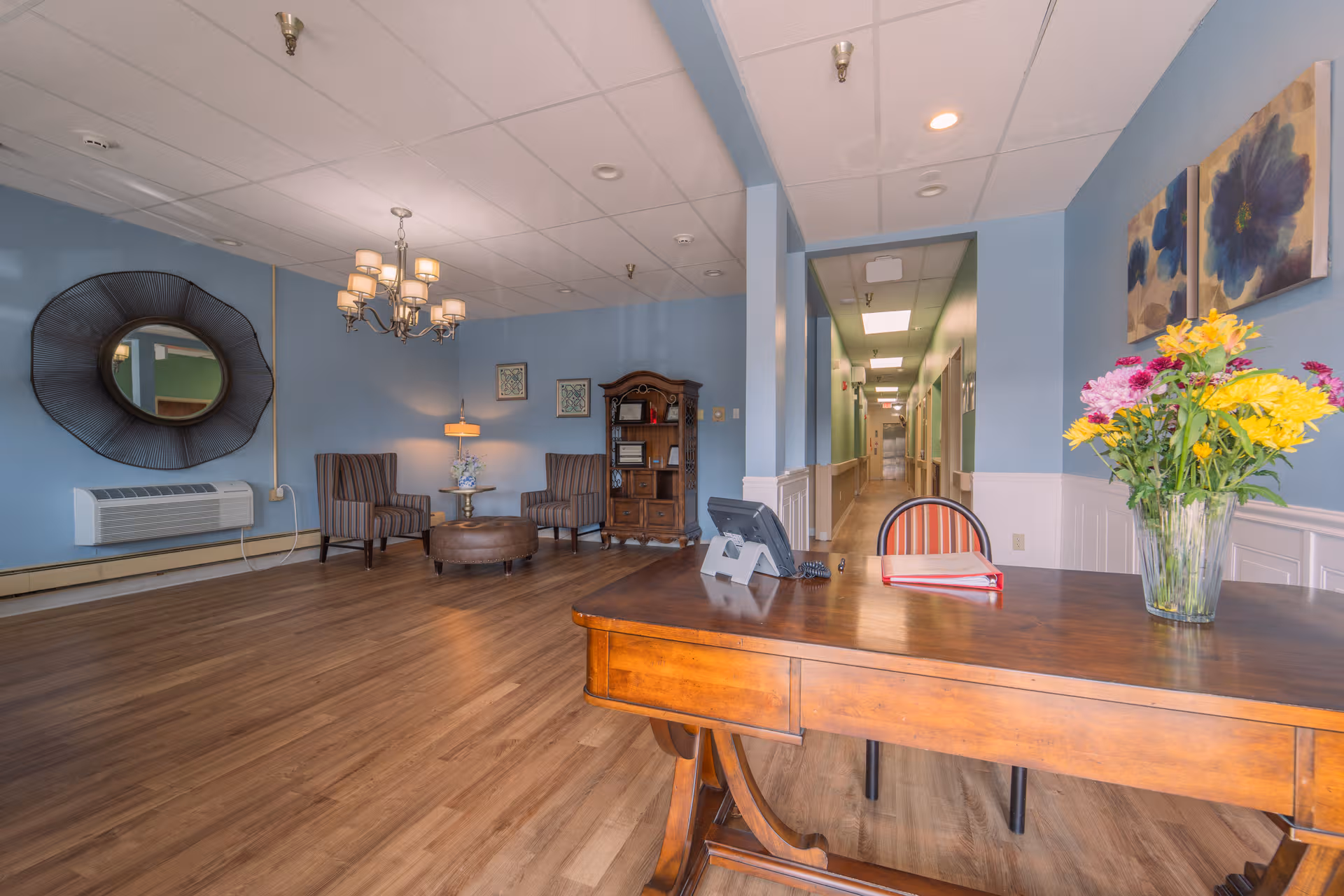 Reception lobby of a senior living facility with blue walls and seating.