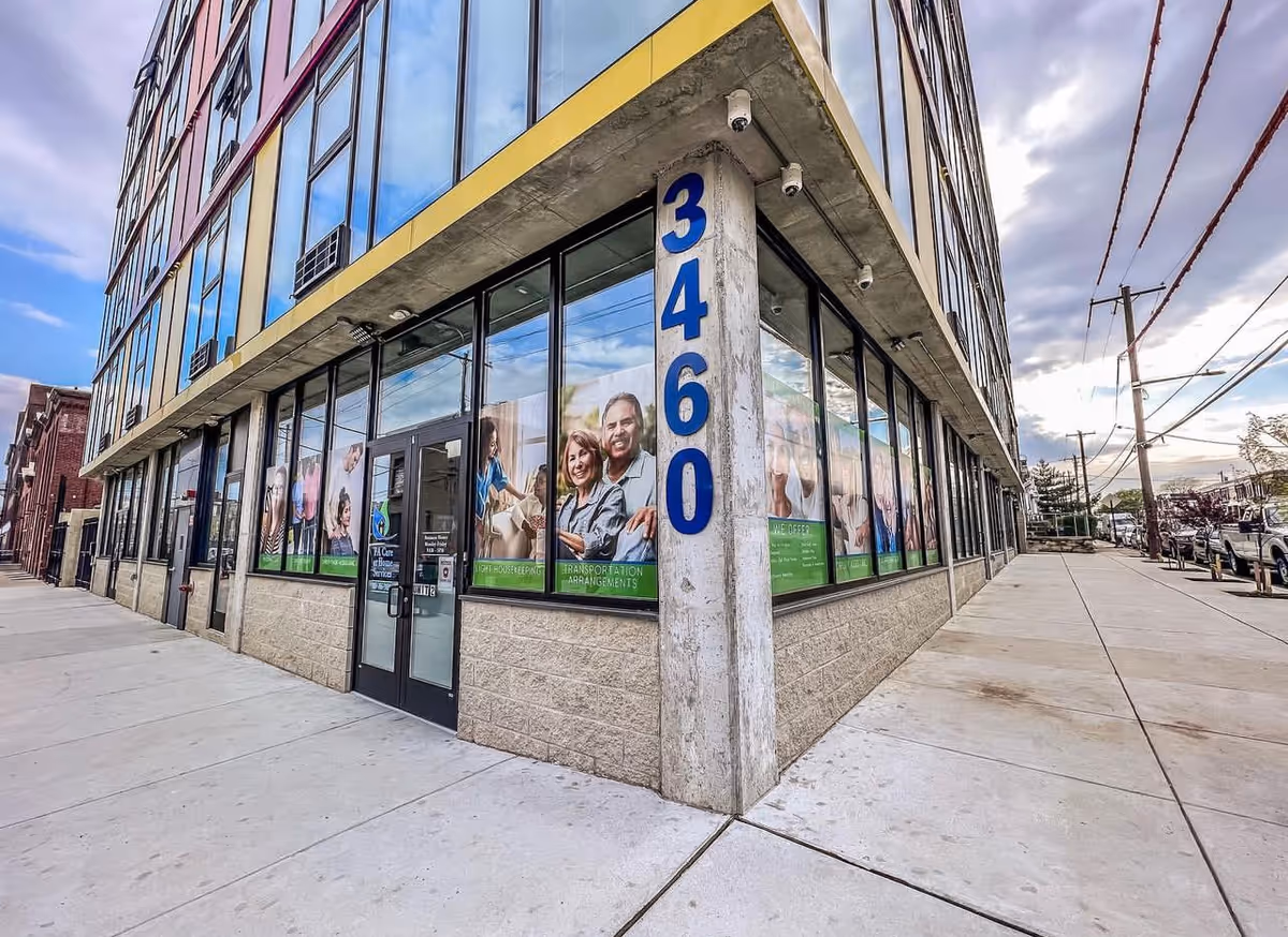 Corner of a modern glass-front building with large windows and blue 3460 pillar.