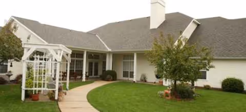 Single-story senior living facility exterior with a curved walkway to the front entrance.