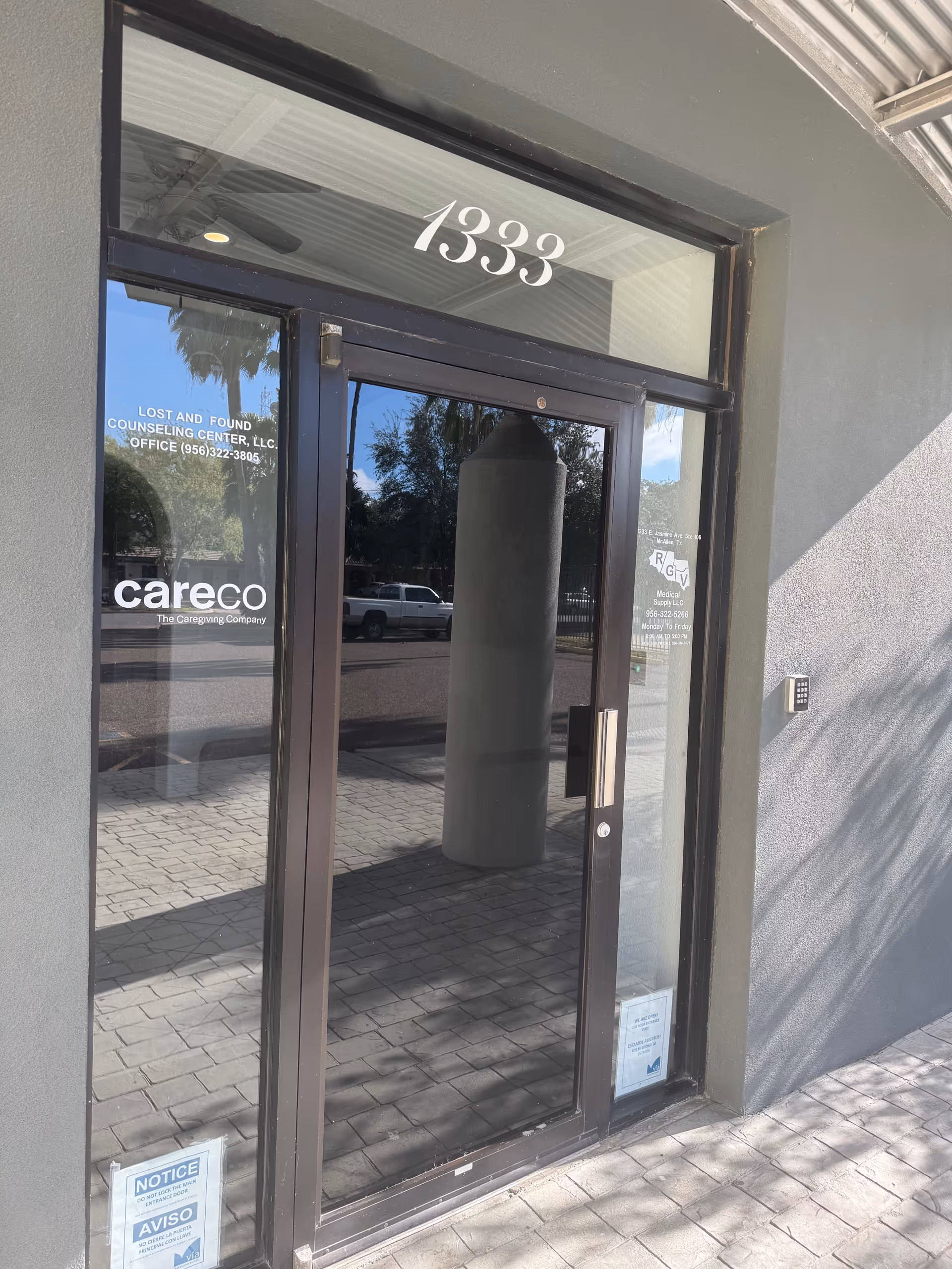 Glass entrance door at CareCo facility with address 1393 and logo visible.