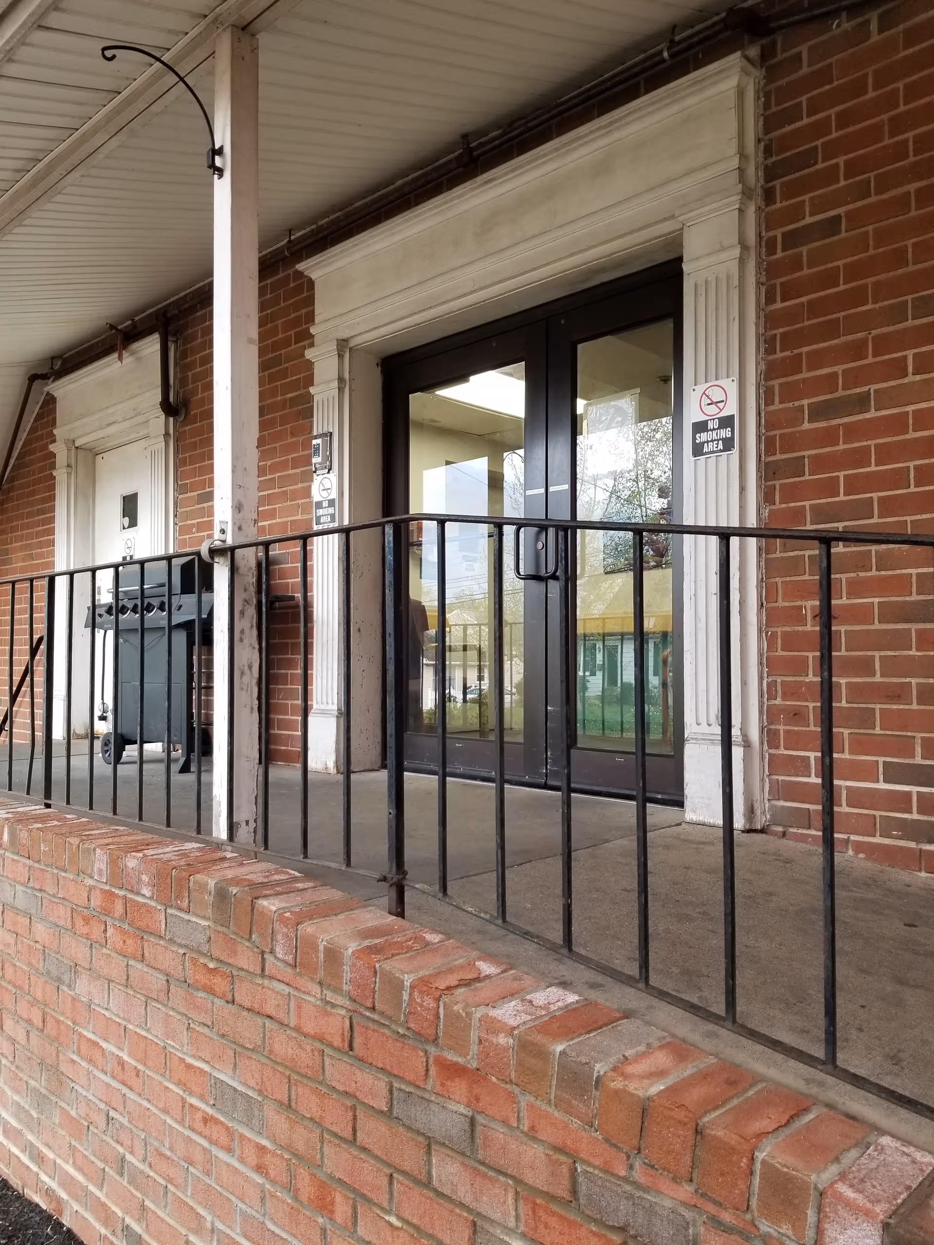 Exterior view of Harborview Doylestown entrance with glass doors, brick walls, and railing.