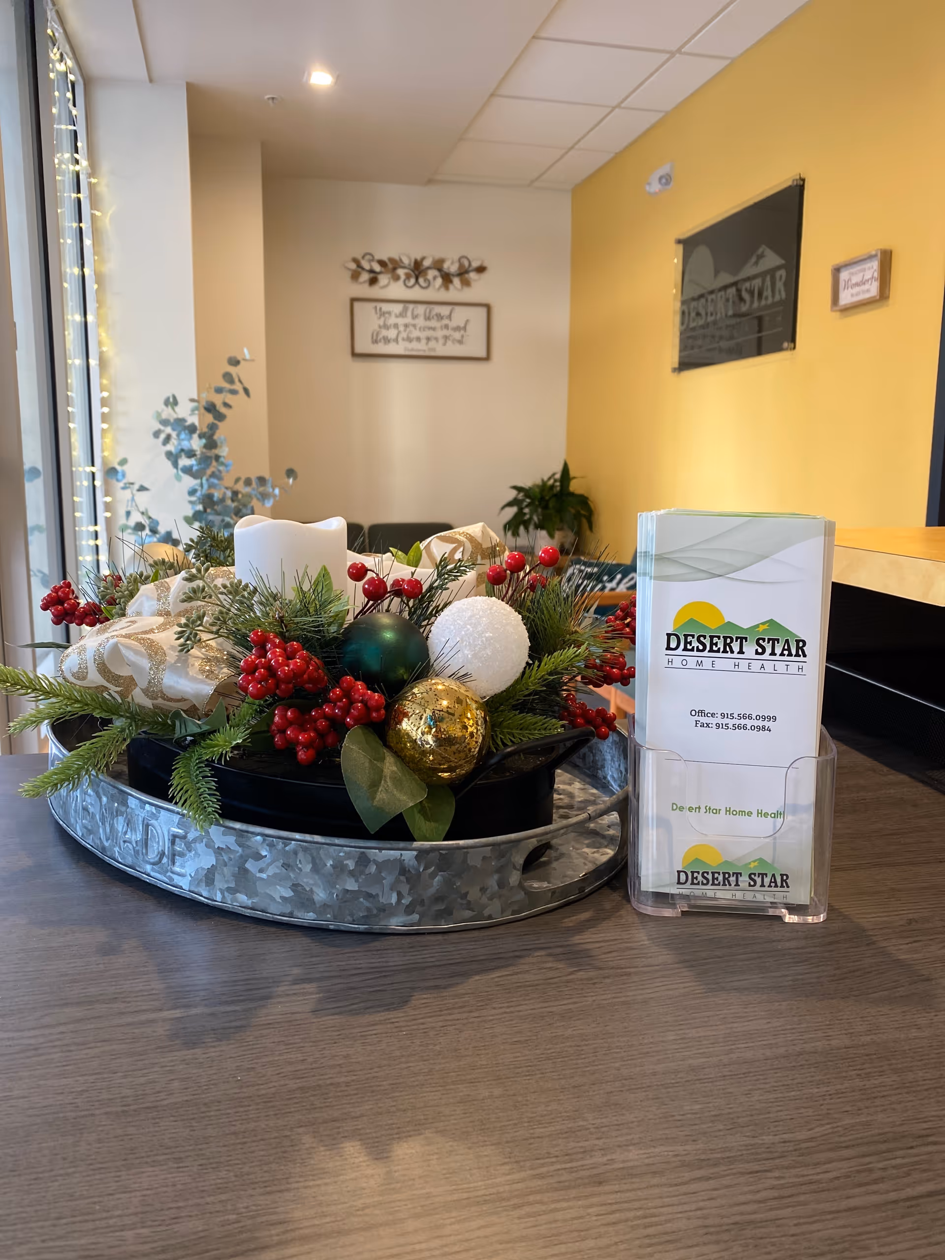Interior reception area with festive centerpiece, Desert Star Home Health brochures, and logo on the wall.