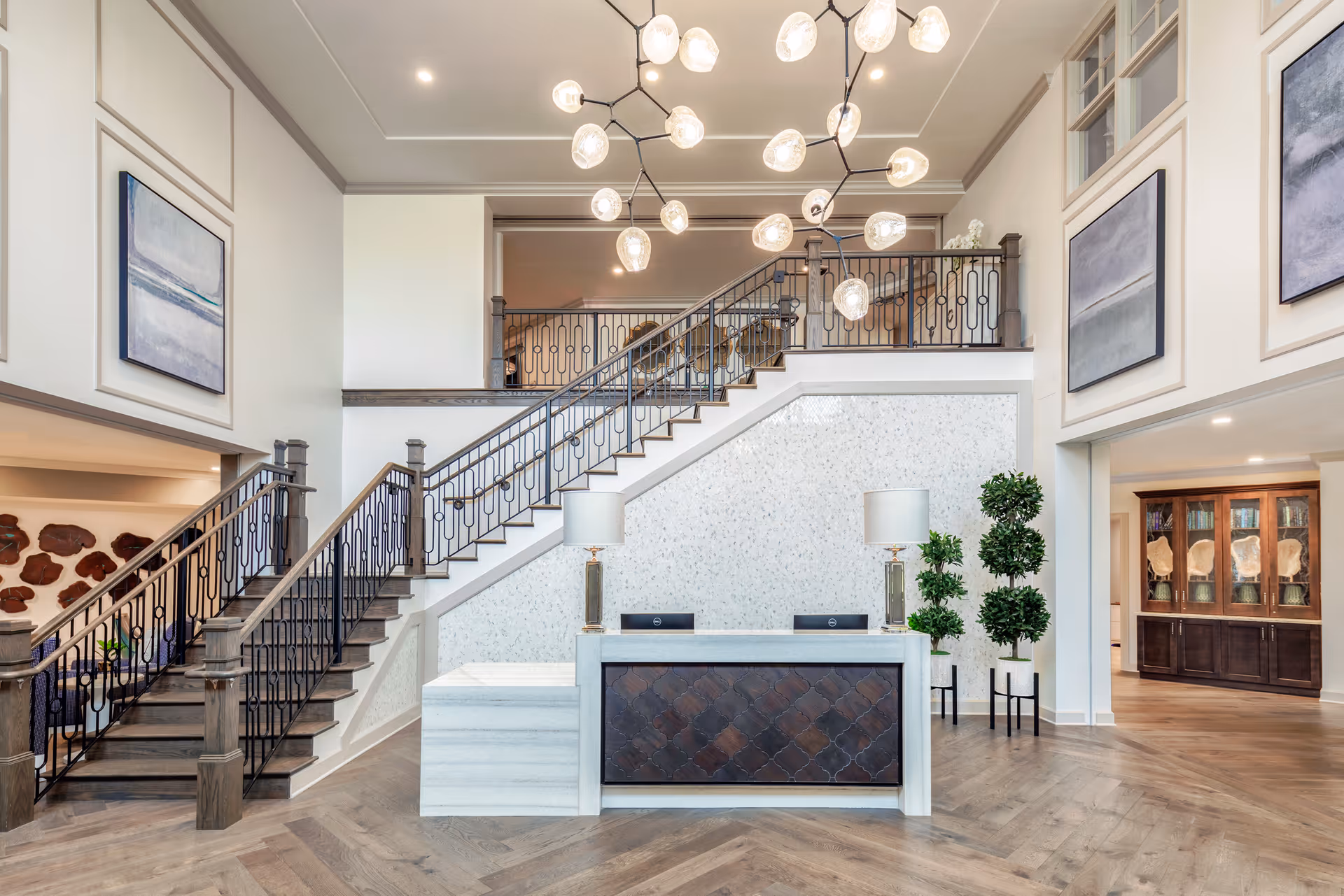 Bright lobby at Arbor Terrace Waugh Chapel featuring a grand staircase and reception.