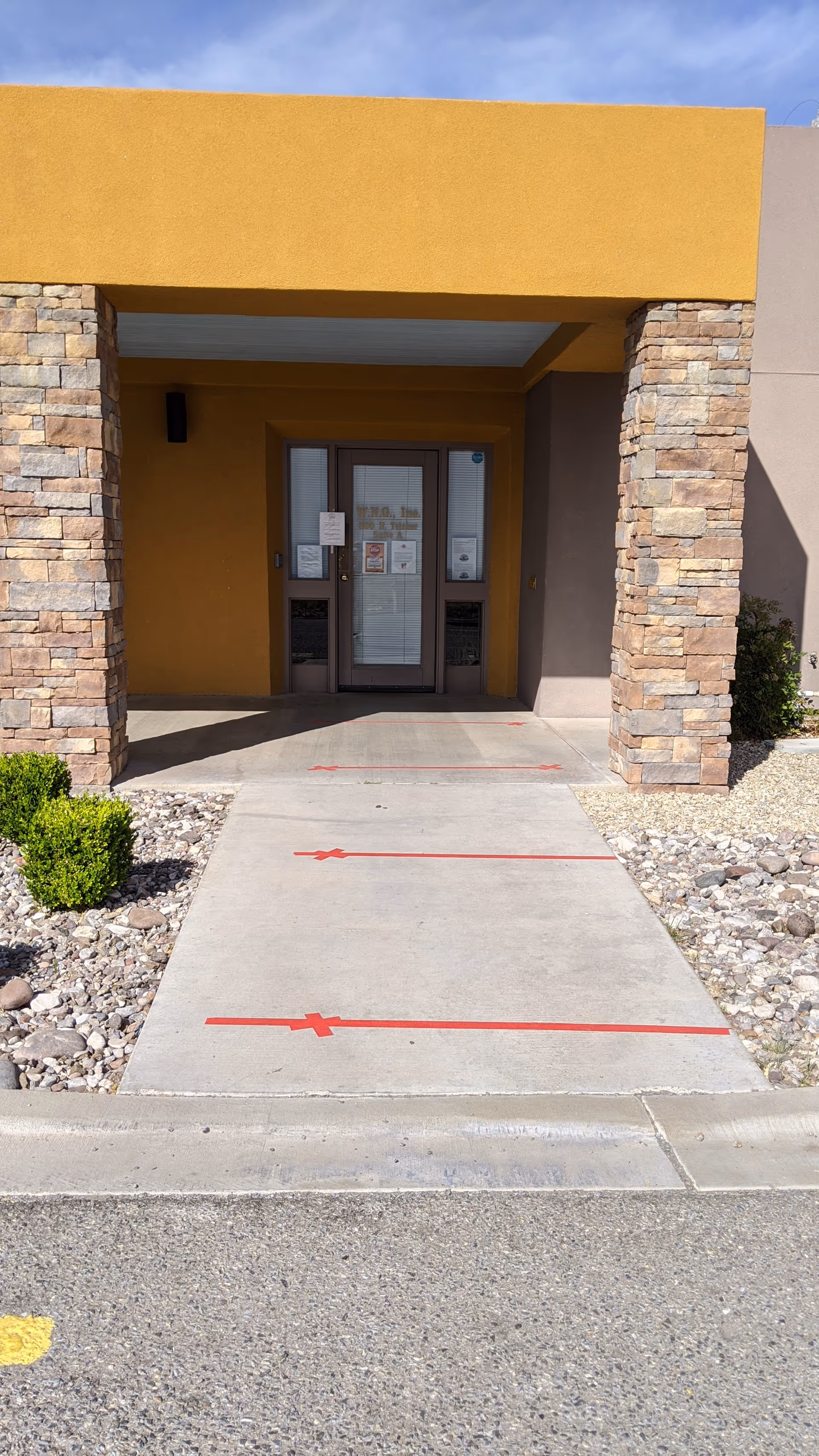 Front entrance of Mountain Shadows Home Care Inc., with a yellow archway and stone columns.