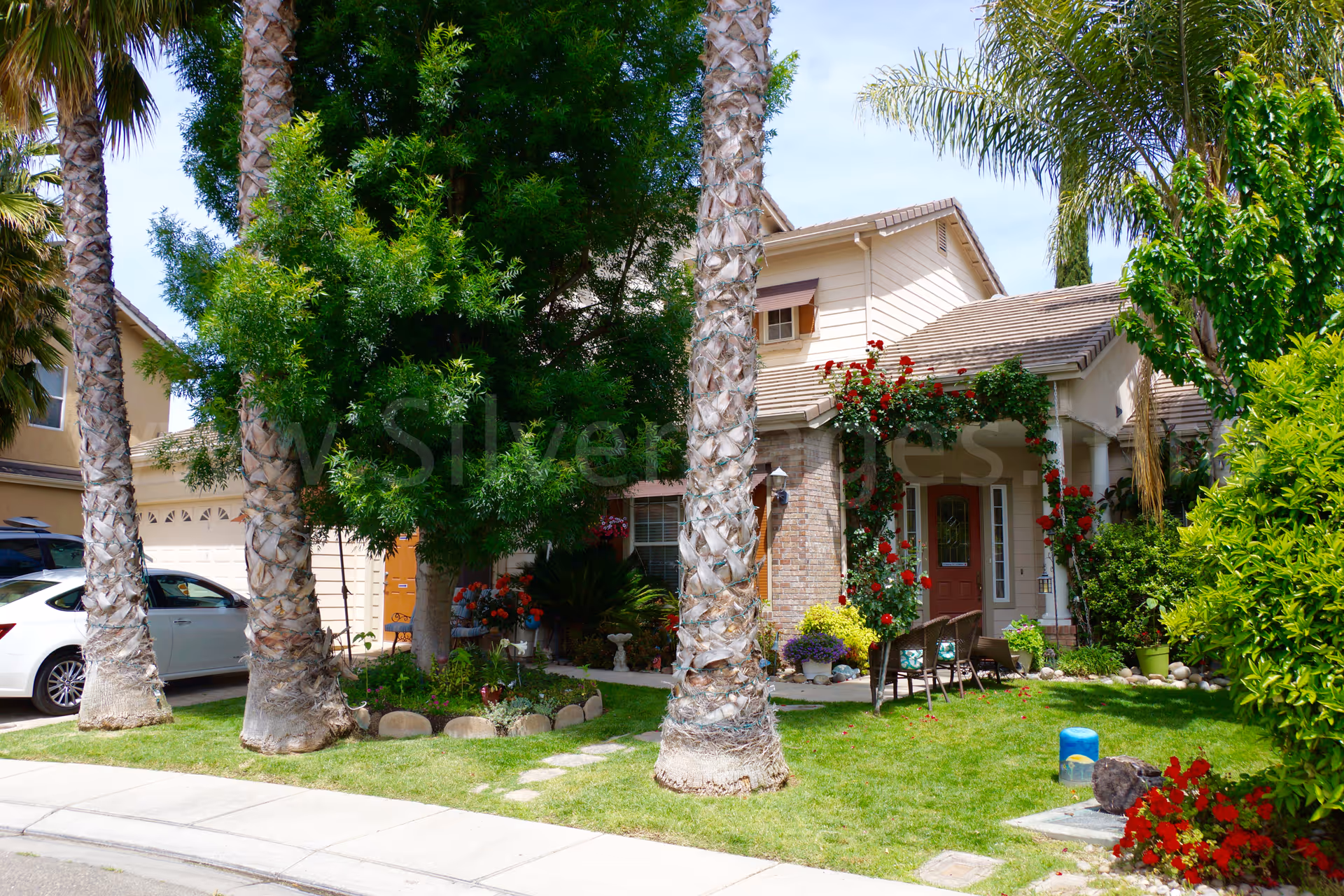 Front view of Corina's Elderly Care Home with garden and outdoor seating.