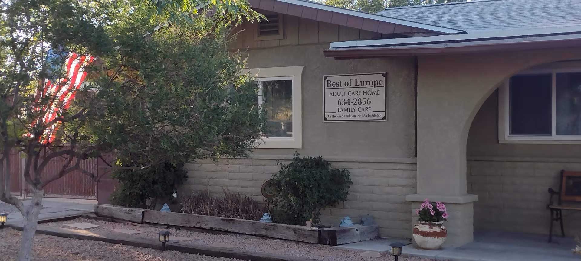 Exterior view of Best of Europe Adult Care Home with sign and porch.