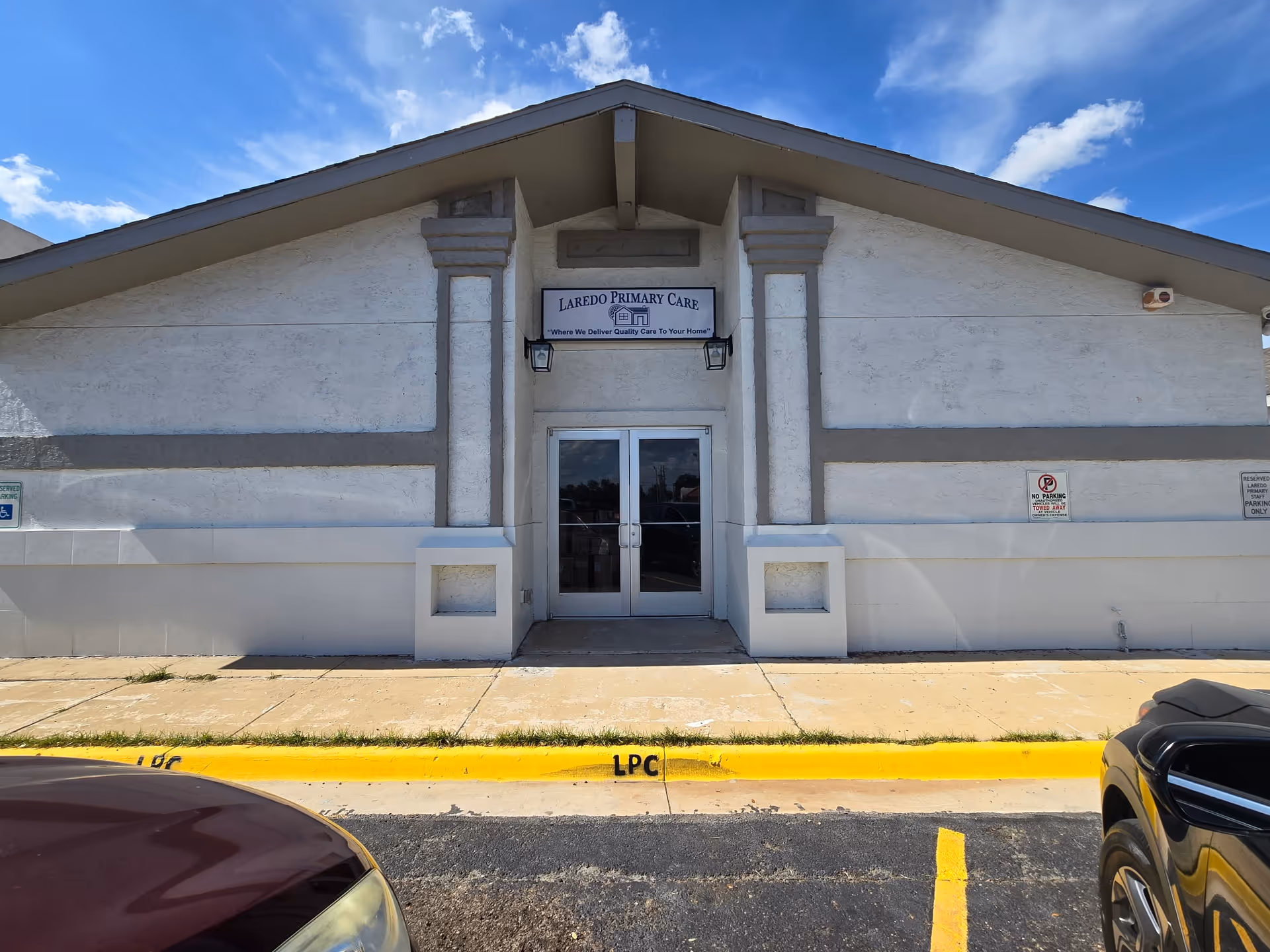 Front exterior of Laredo Primary Care building with double doors and blue sky.