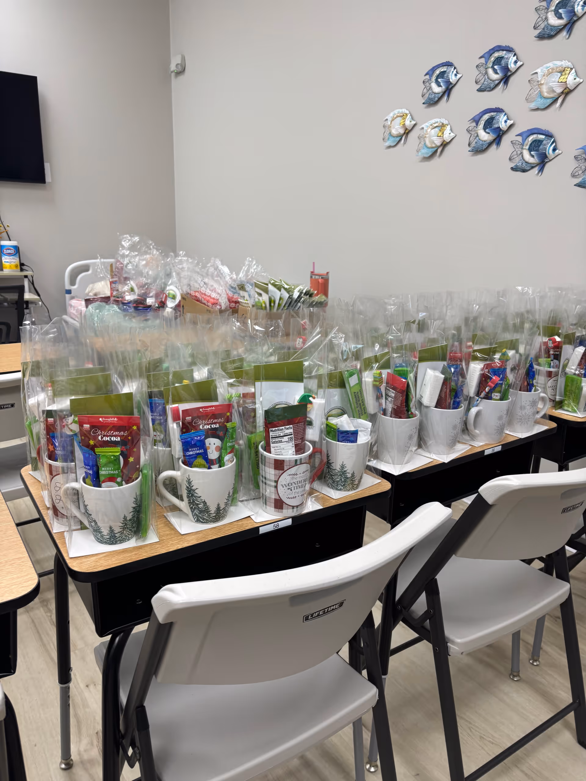 Indoor room with rows of wrapped gift baskets arranged on desks.