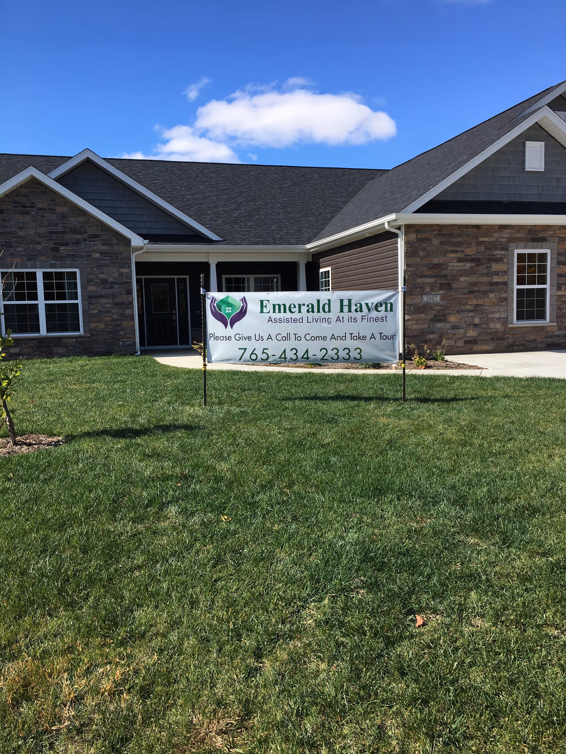 Front of Emerald Haven facility with a banner on the lawn advertising tours.