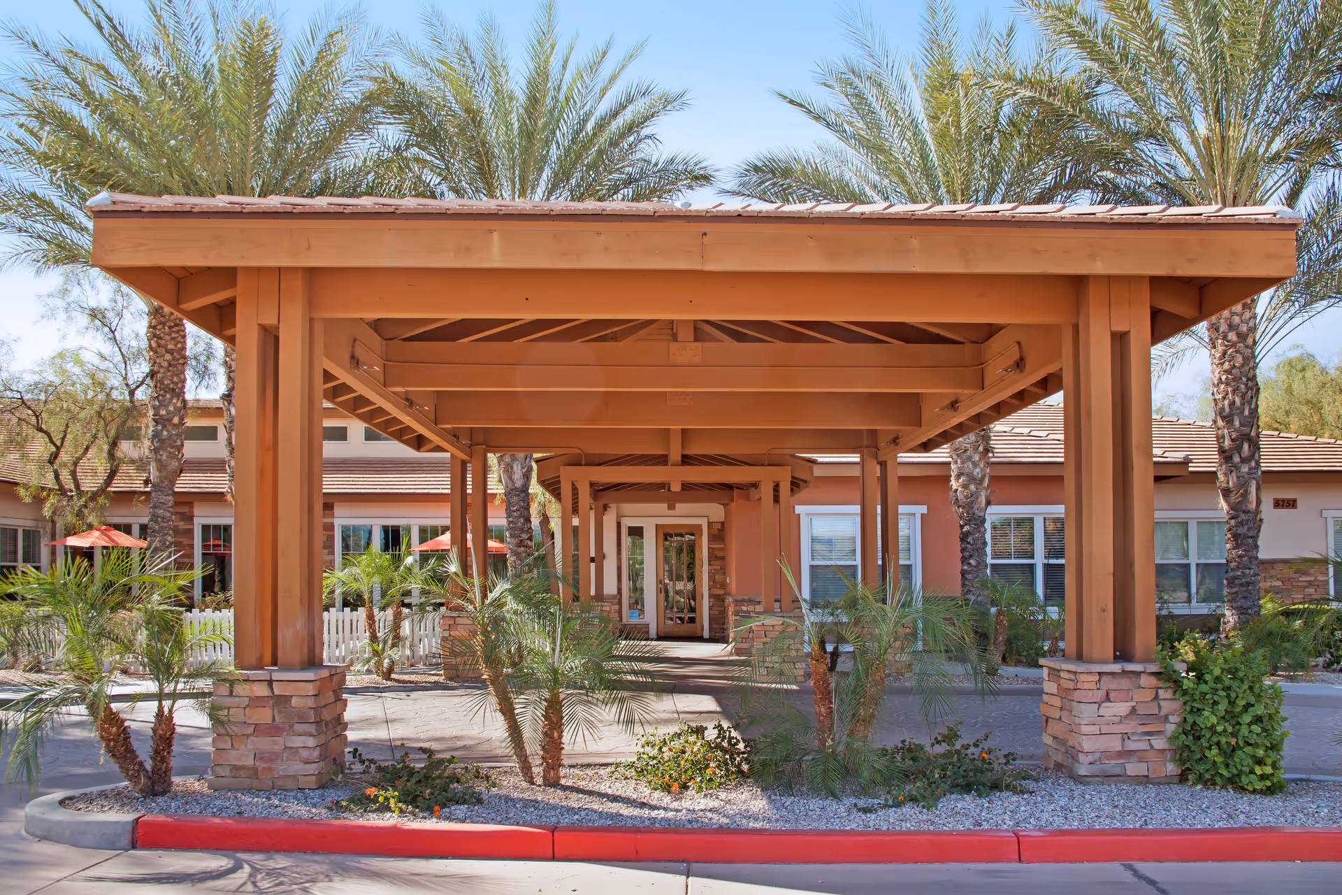 Wood-framed covered entrance with stone pillars leads to Sunrise of Chandler.