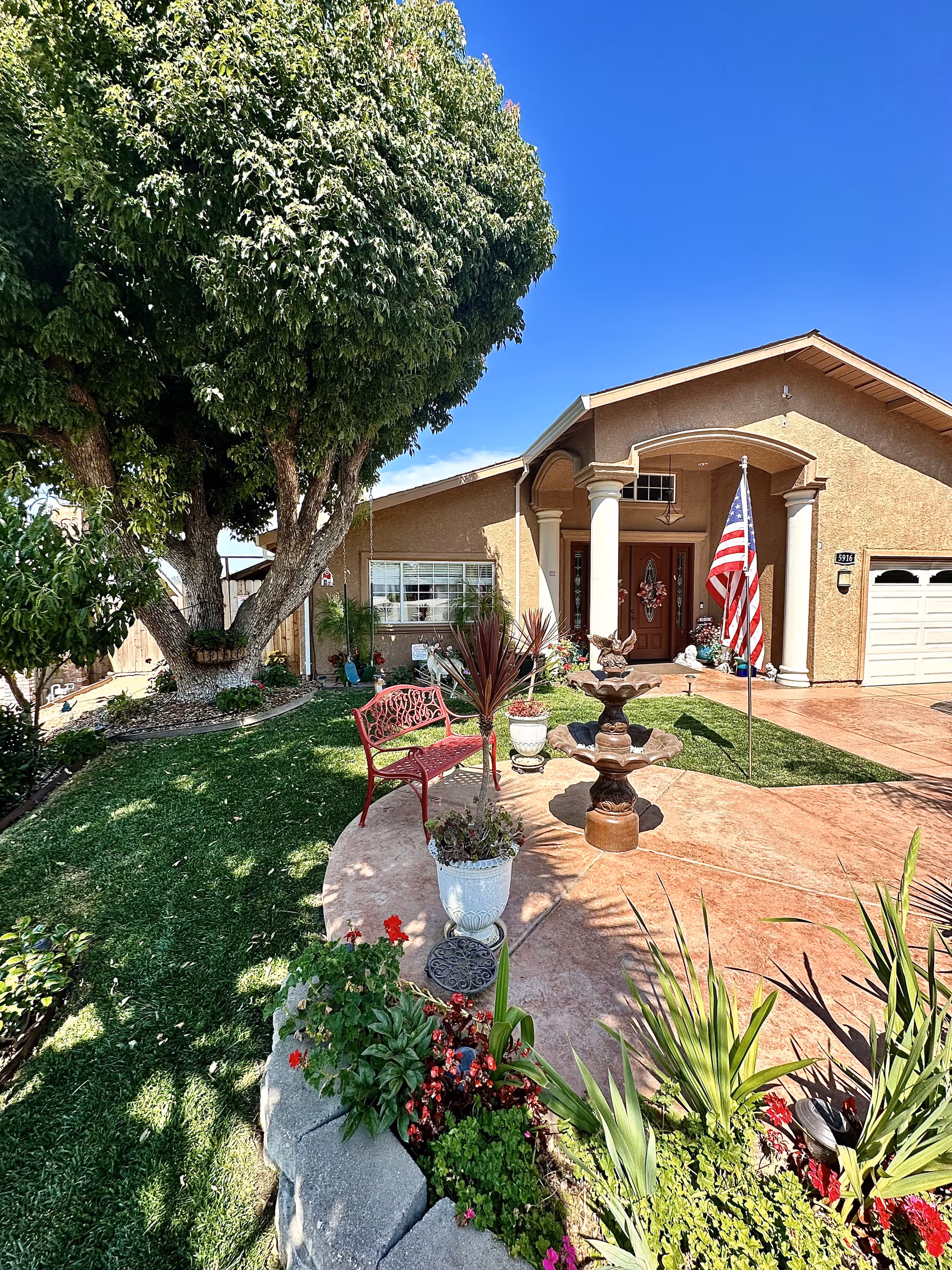 Front exterior of Brookhaven Home Care with landscaped yard, bench, fountain, and flag.