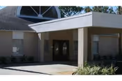 Front entrance of a Safe Harbor senior living facility with a covered walkway.
