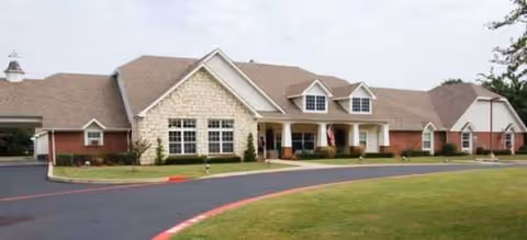Front exterior view of a Brookdale Texarkana senior living building with a curved driveway and lawn.