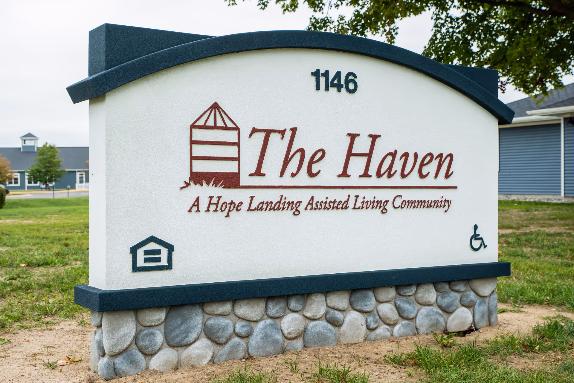 Curved white sign reads The Haven with Hope Landing Assisted Living Community at the entrance.