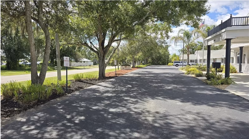 Arcadia Oaks Assisted Living exterior with a tree-lined driveway and covered entrance.