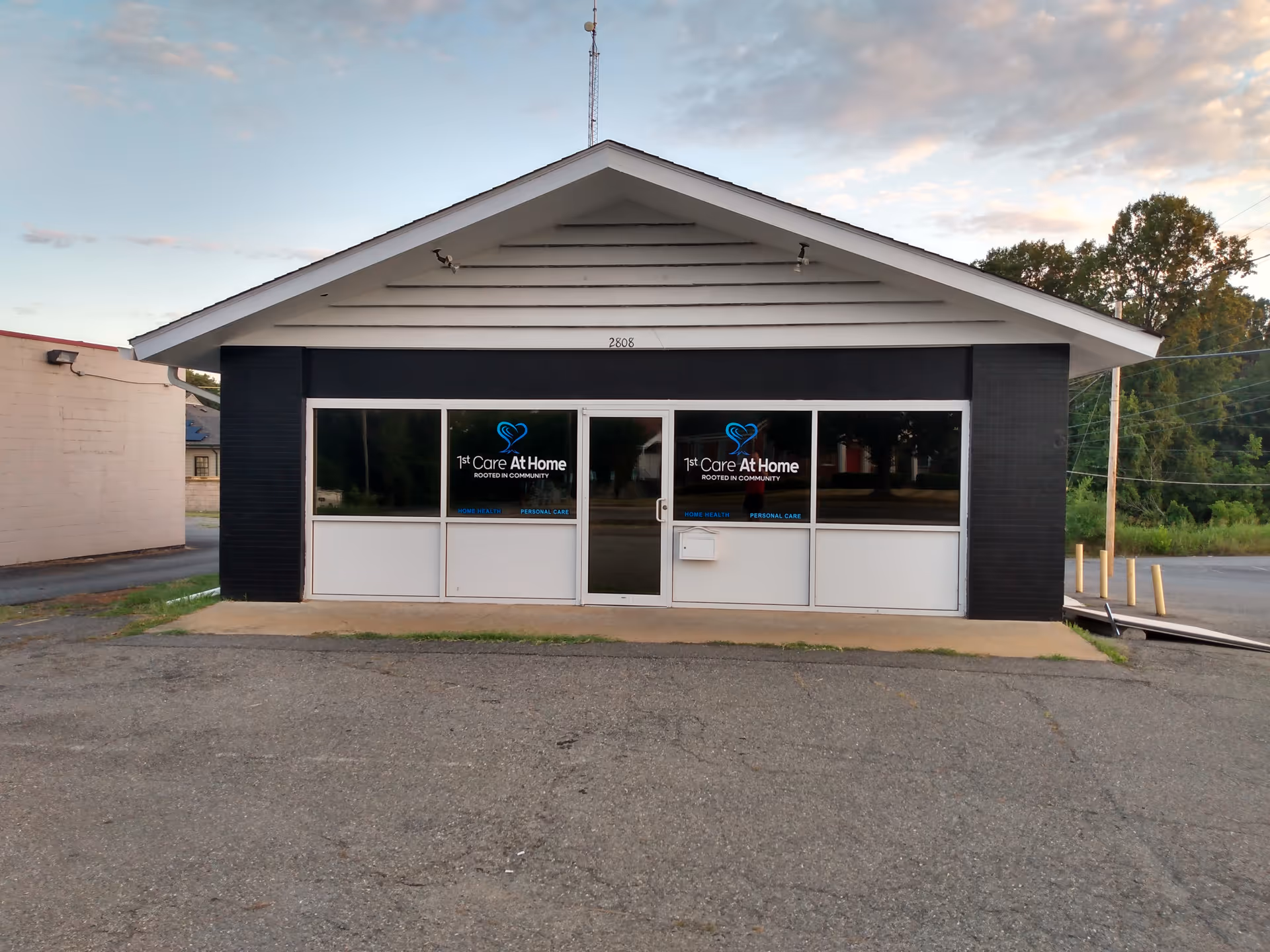 Front view of a small facility with 1st Care At Home signage on windows.
