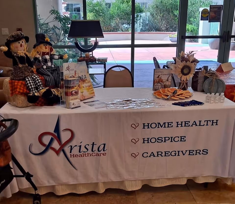 An information table with Arista Healthcare banner and promotional materials indoors.