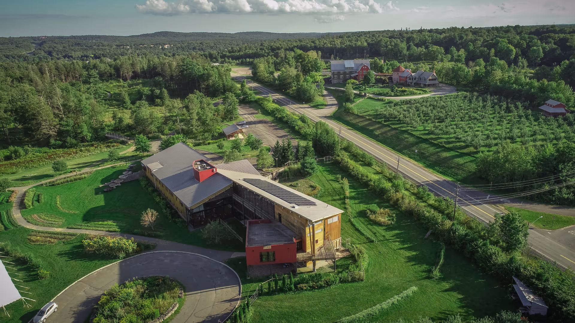 Aerial view of a modern senior living campus with green lawns and woodlands
