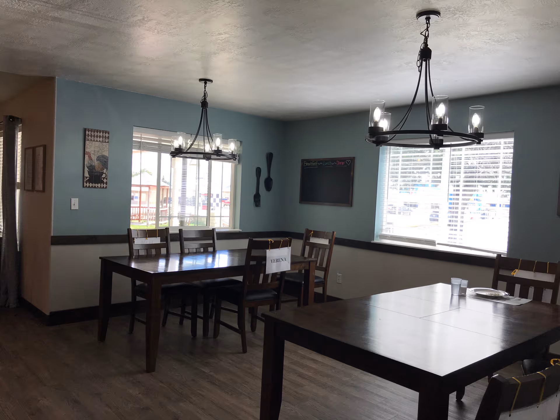 Dining room at Beehive Homes of Cut Bank with tables and chandeliers