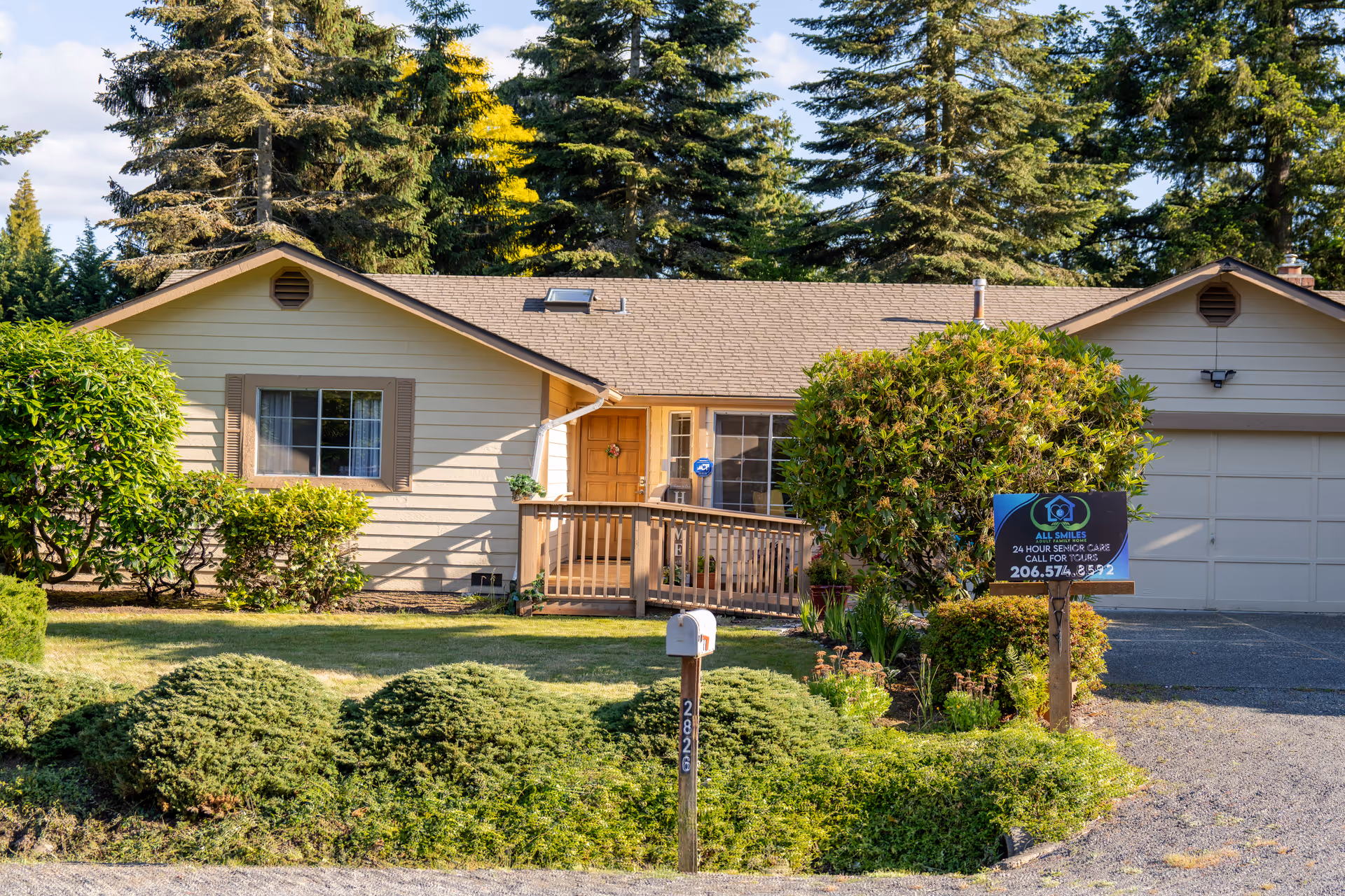 Single-story house exterior with front porch and landscaped yard advertising All Smiles Adult Family Home.