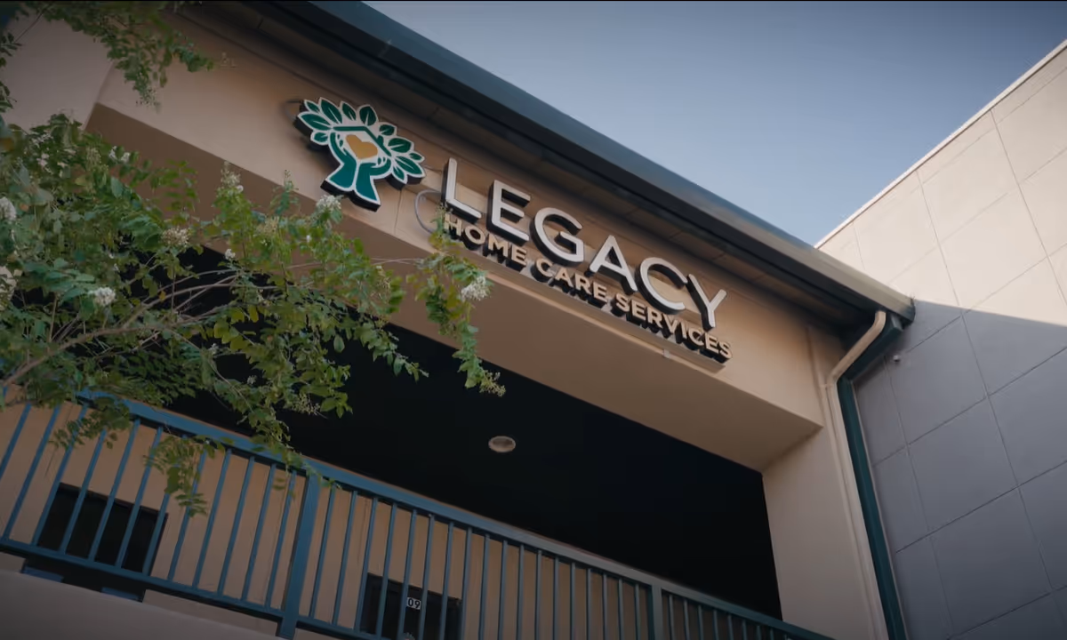Front view of Legacy Home Care Services building with sign and tree branches.