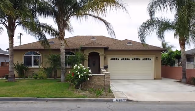 Front exterior view of Carnelian Villas Home Care, a residence with a driveway and palm trees.