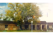 Front exterior of Garden Valley Retirement Village, a single-story building with trees and a lawn.