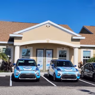 Front view of Invigorate Wellness Medical building with two blue cars in the parking lot.