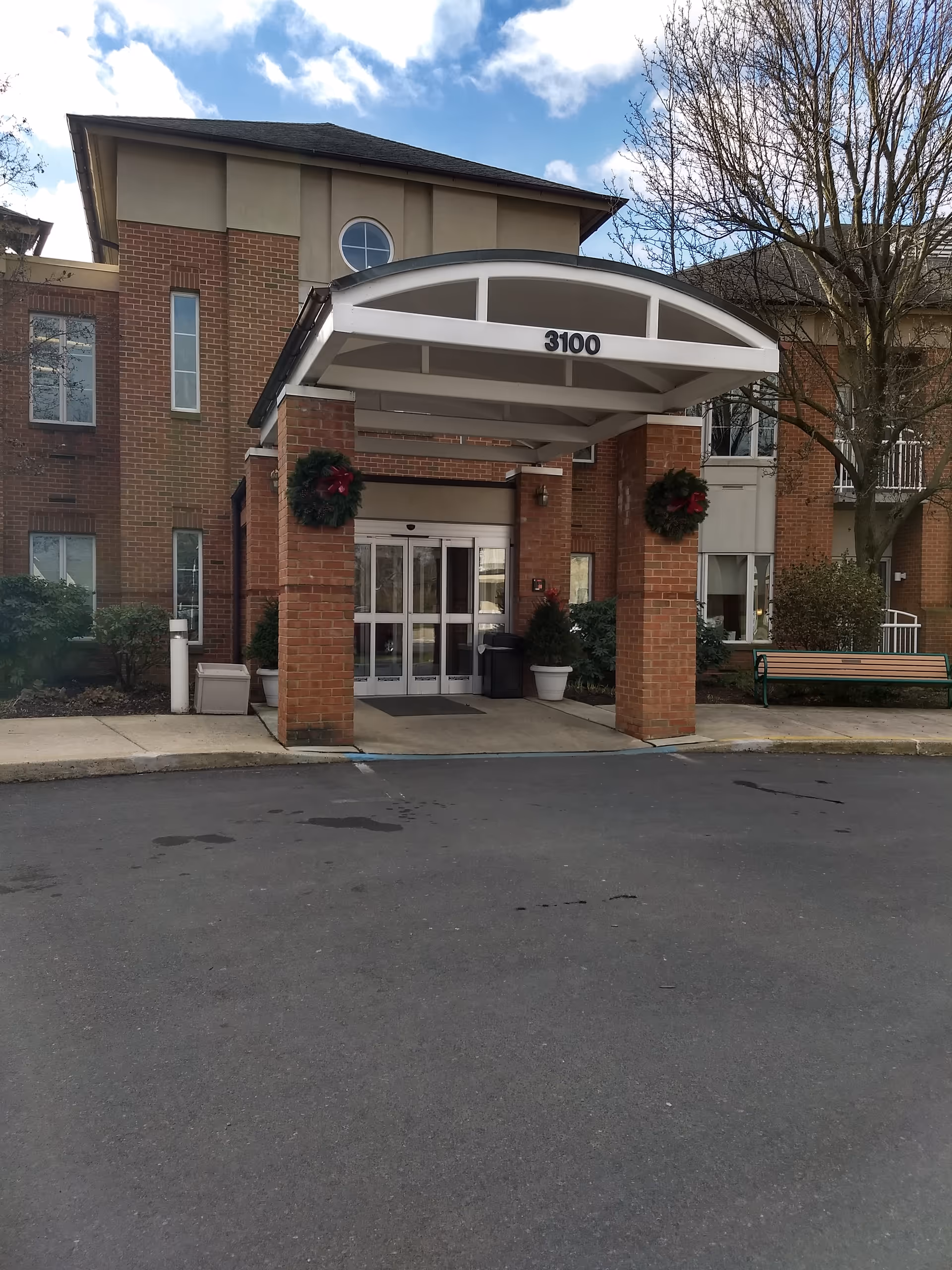 Exterior view of Kirkland Village entrance with brick columns, arched canopy, and wreaths.